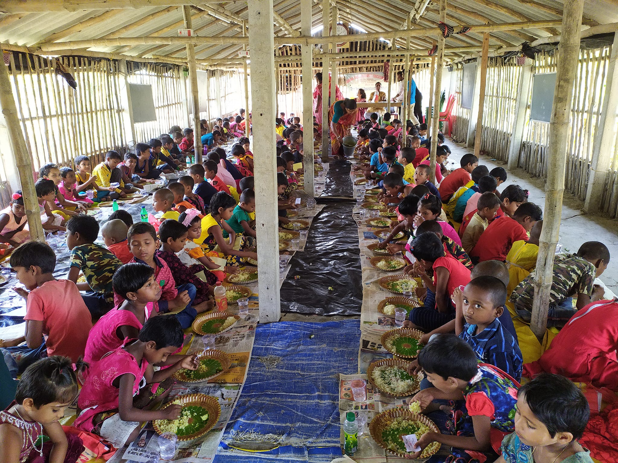 To celebrate Mrs. Anvesha Topdar's birthday, Mr. Arjun Bagchi served a meal to 350 students at SAI's Education Center in the Sundarbans, featuring rice, dal, fry, meat, chutney, pappad, sweets, and ice cream.